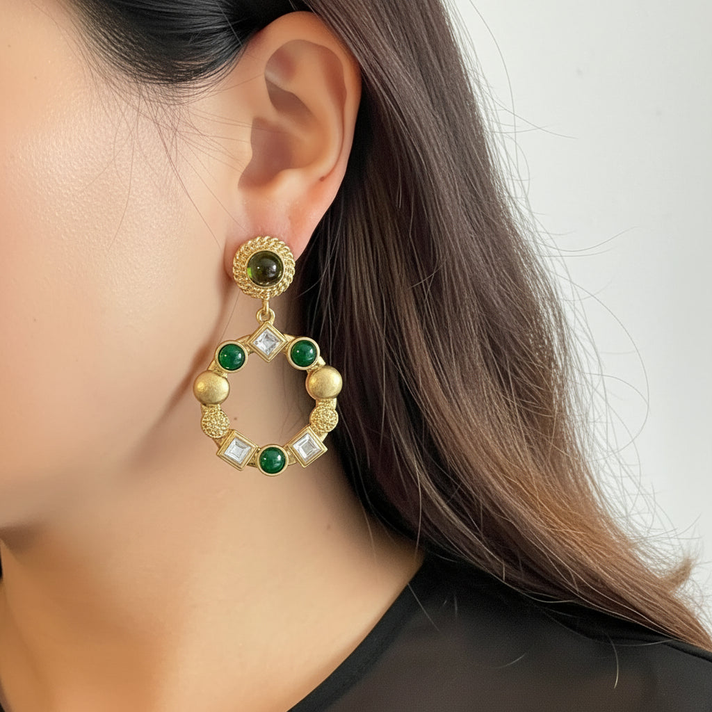 Close-up of a person wearing a gold and green earring with a blurred background
