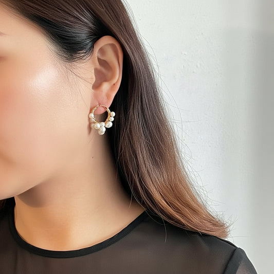 Close-up of a person wearing a pearl earring against a neutral background