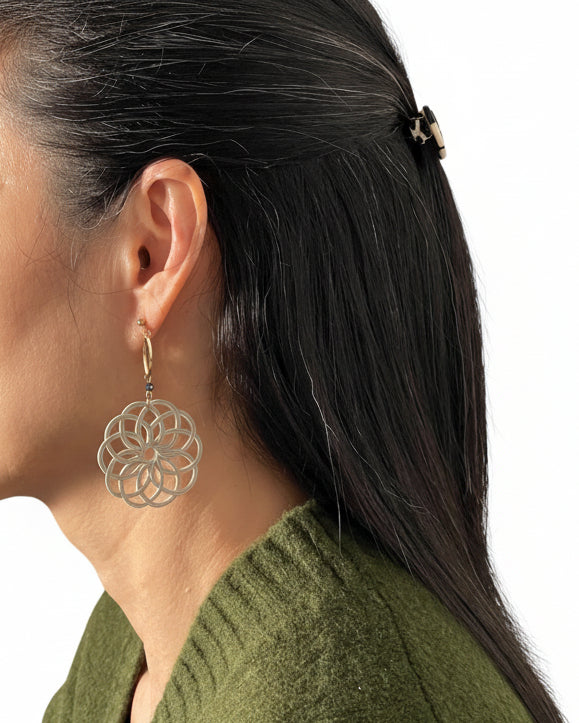 Model wearing handmade Japanese asymmetrical grey flower earrings with one gold-lined detail