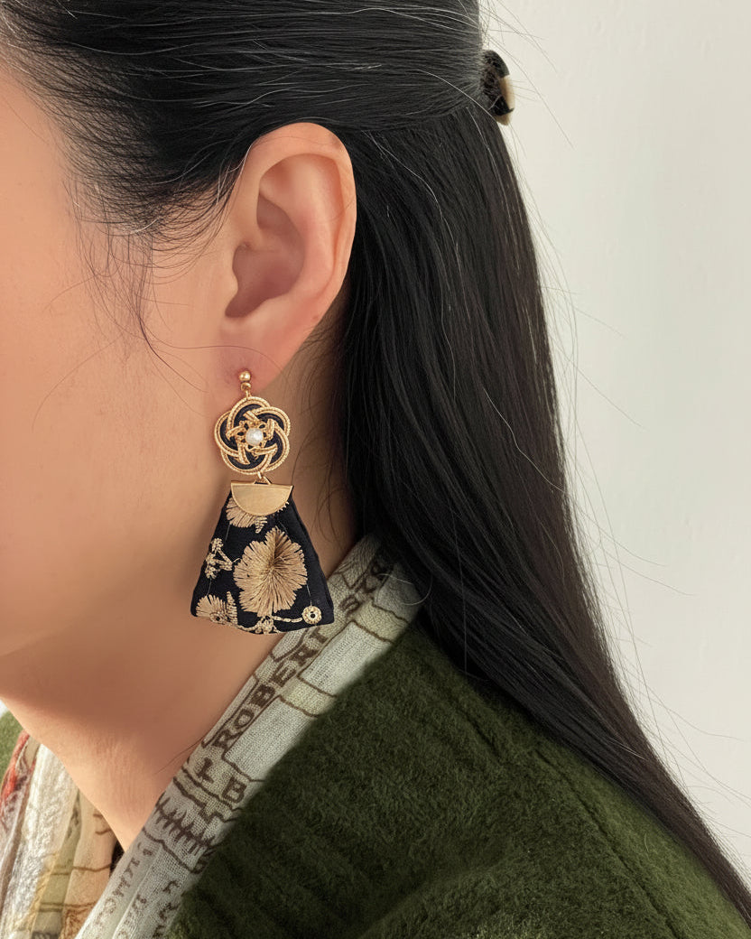 Model wearing handmade Japanese mizuhiki earrings with pearl and navy embroidered fan detail